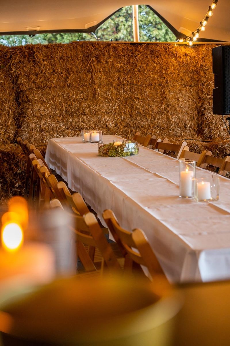 Lange feesttafel met kaarslicht in de tent van Harbor