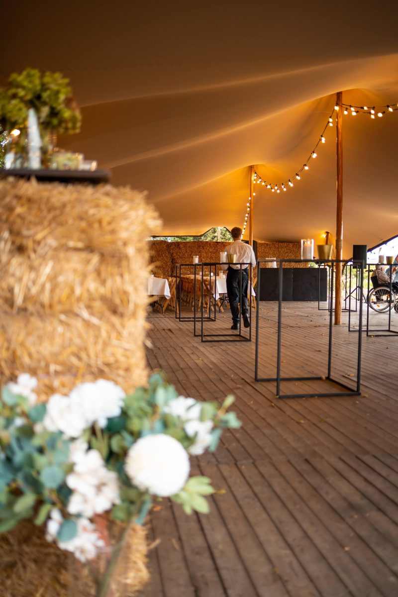 Binnenin de sailcloth-tent van Harbor, met lichtslingers en bloemen